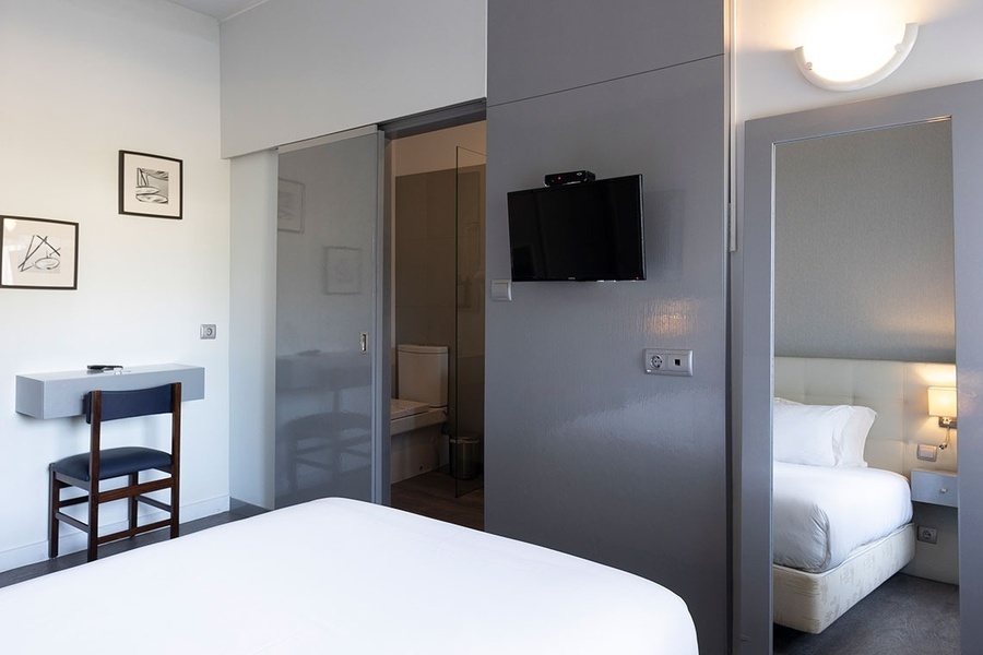 a hotel room with a sliding glass door leading to a bathroom