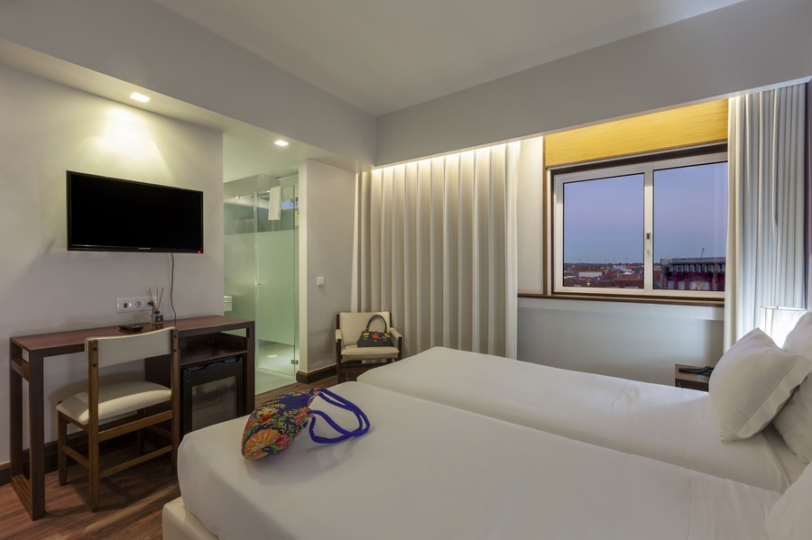 um quarto de hotel com duas camas e uma televisão