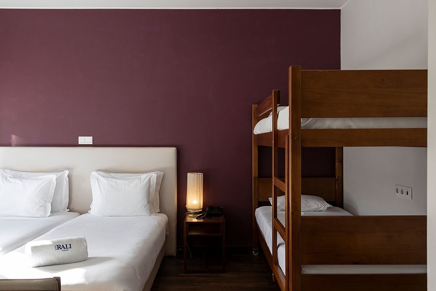 um quarto de hotel com duas camas e duas beliches