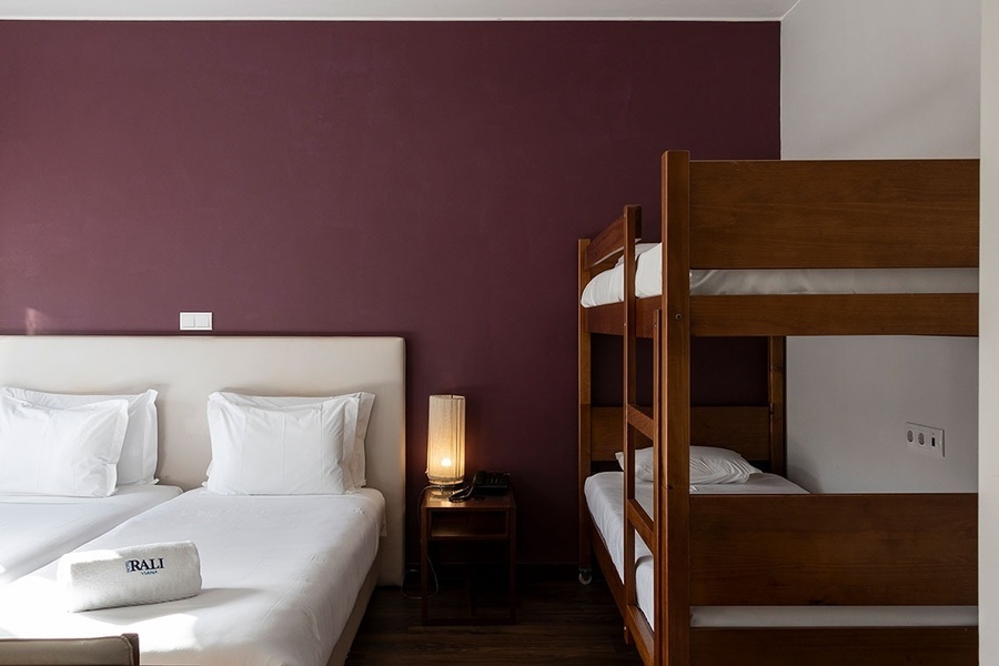 a hotel room with two beds and two bunk beds