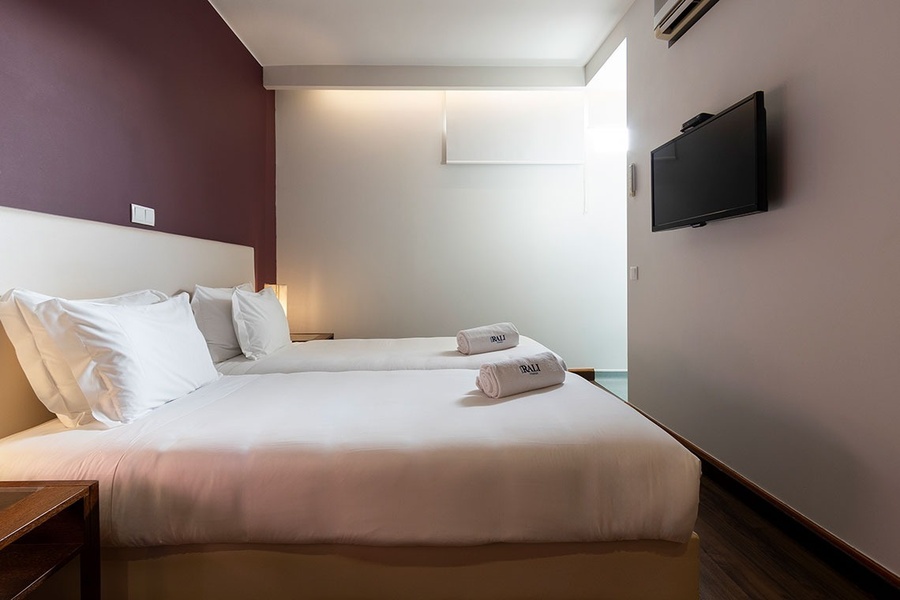 um quarto de hotel com duas camas e uma tv