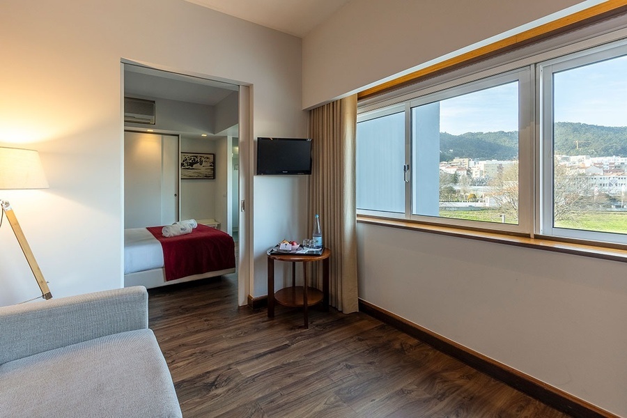 a hotel room with a bottle of water on a table