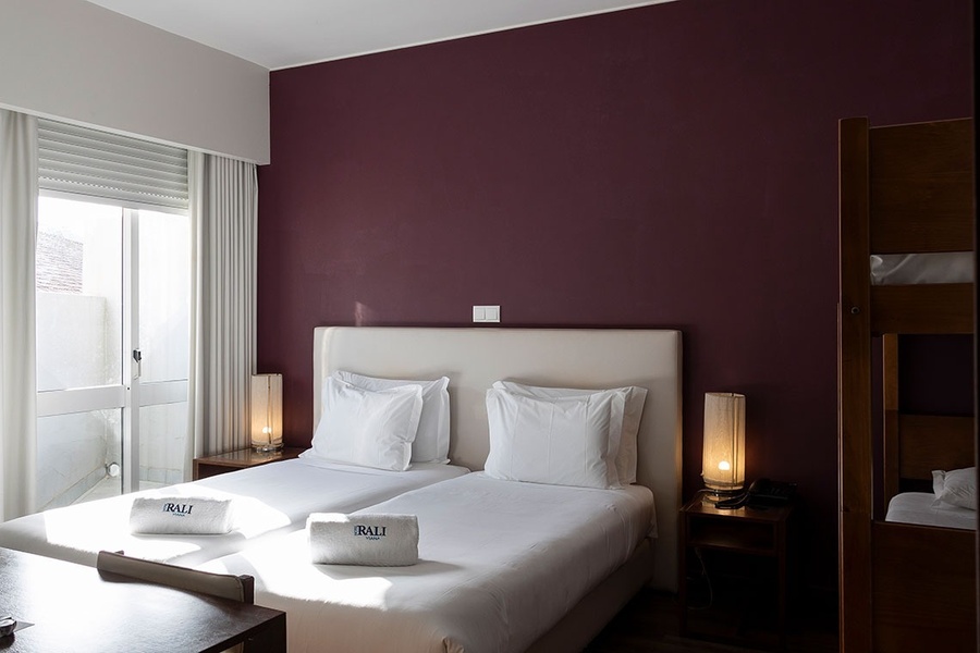 um quarto de hotel com duas camas e uma parede roxa