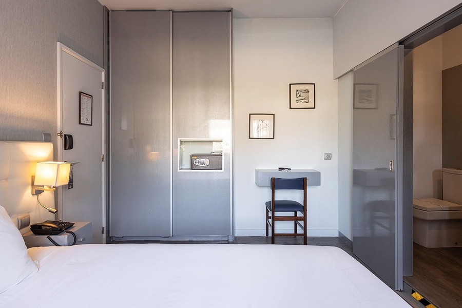 um quarto de hotel com uma cama e uma cadeira