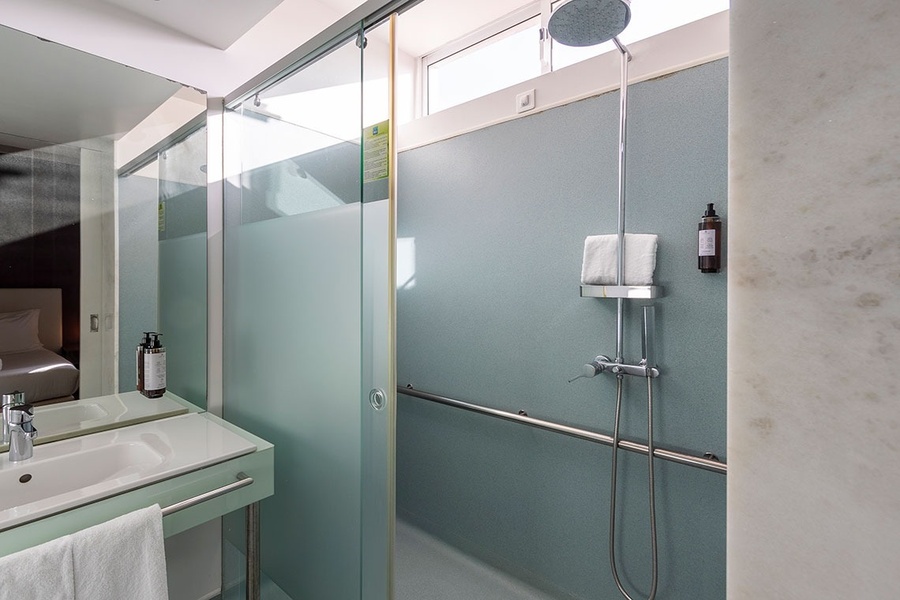 um banheiro com portas de vidro e um chuveiro