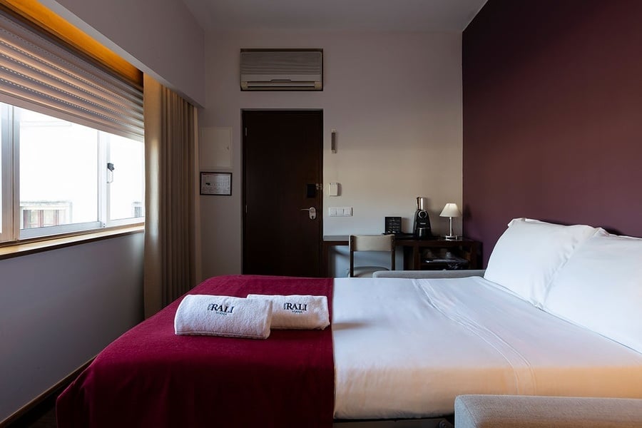 una habitación de hotel con una cama y un sofá y toallas que dicen irali