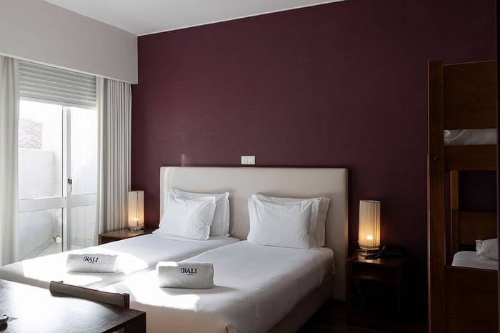 una habitación de hotel con dos camas y una pared morada