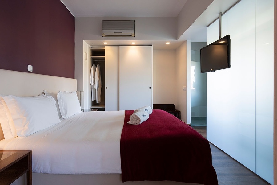 um quarto de hotel com uma cama e uma televisão