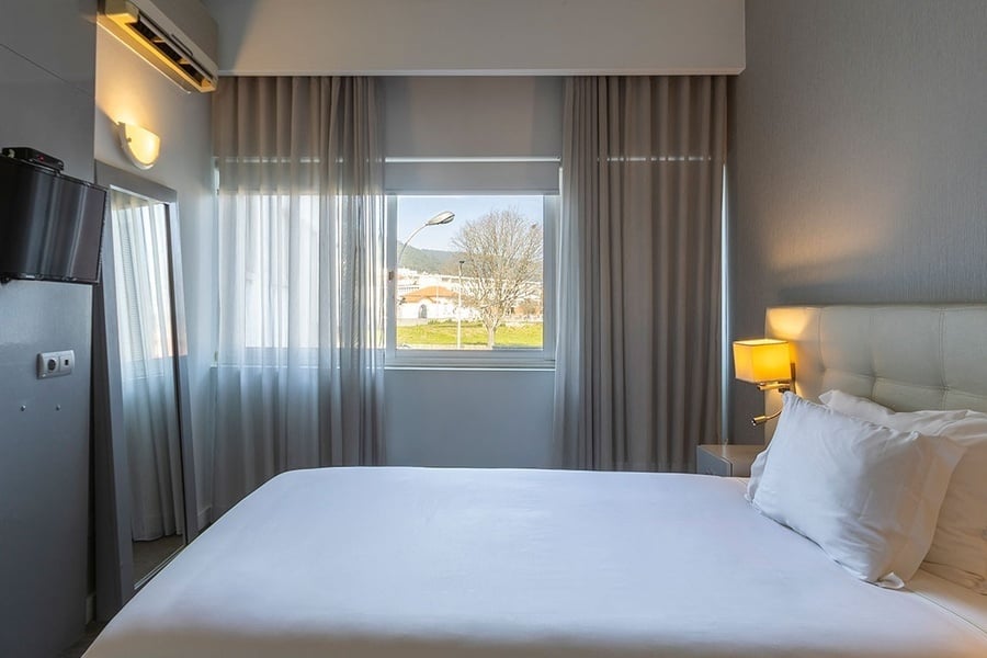 a hotel room with a bed and a large window