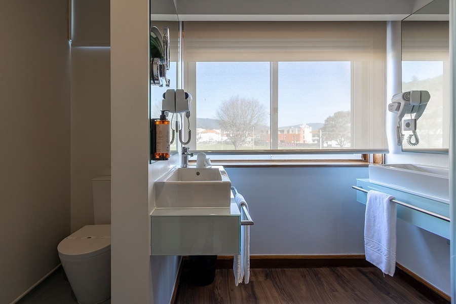 a bathroom with a sink toilet and a window