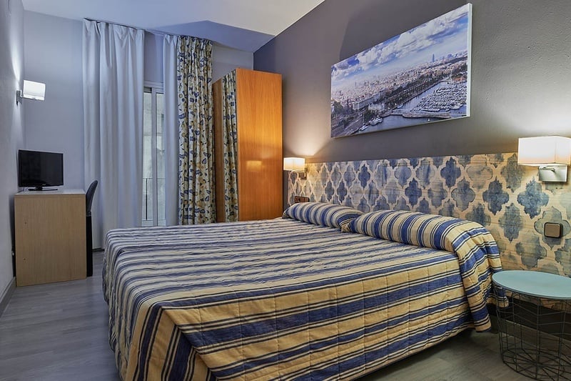 a hotel room with a large painting on the wall above the bed