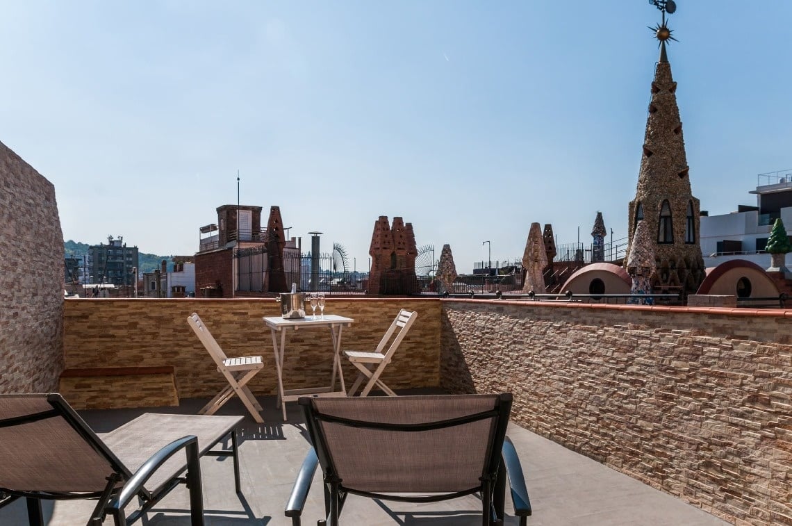 una mesa y sillas en una terraza con una torre en el fondo