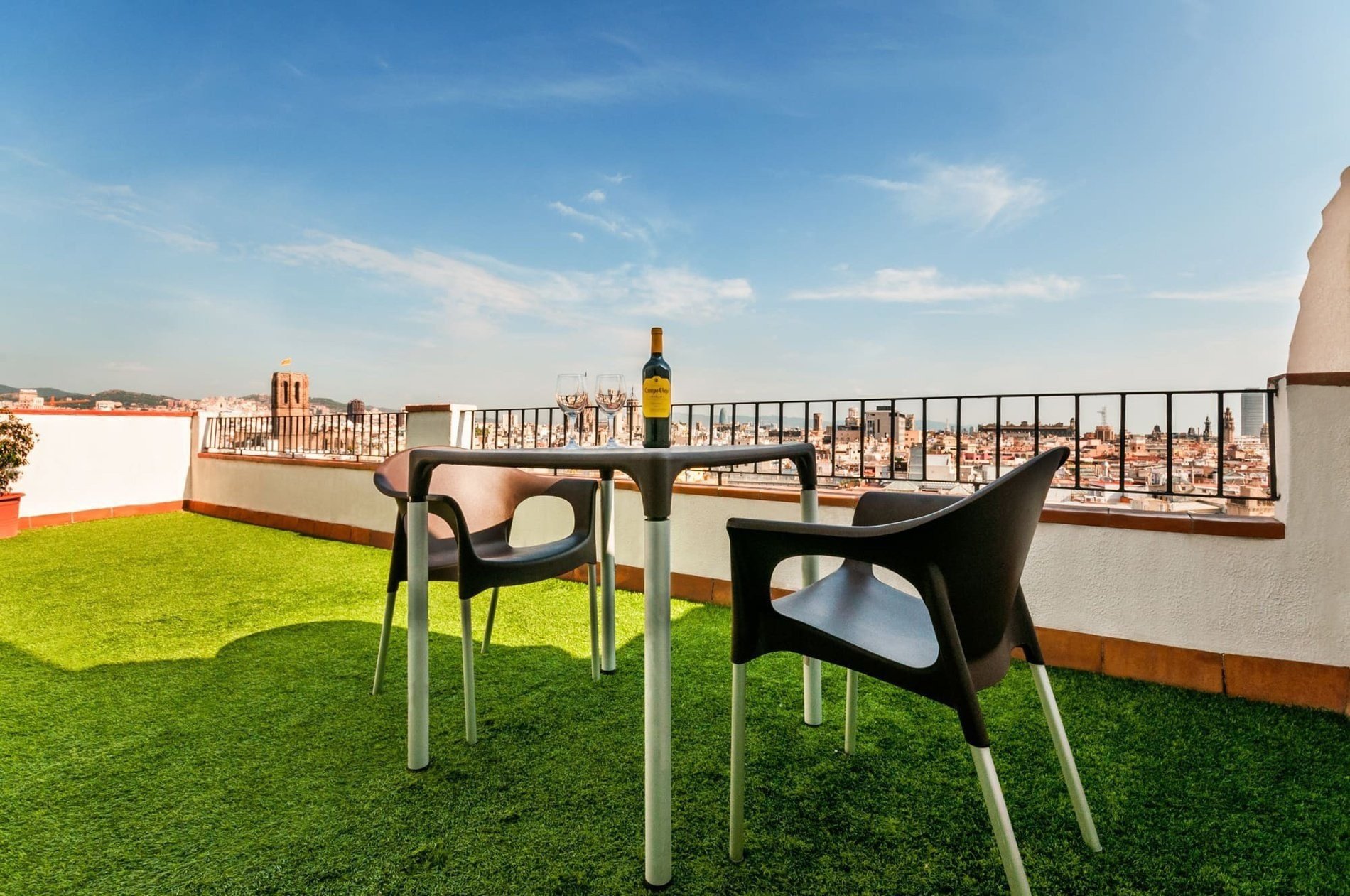 a table with two chairs and a bottle of wine on it