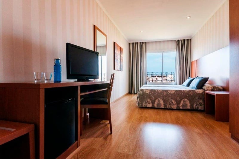 una habitación de hotel con una cama y una televisión