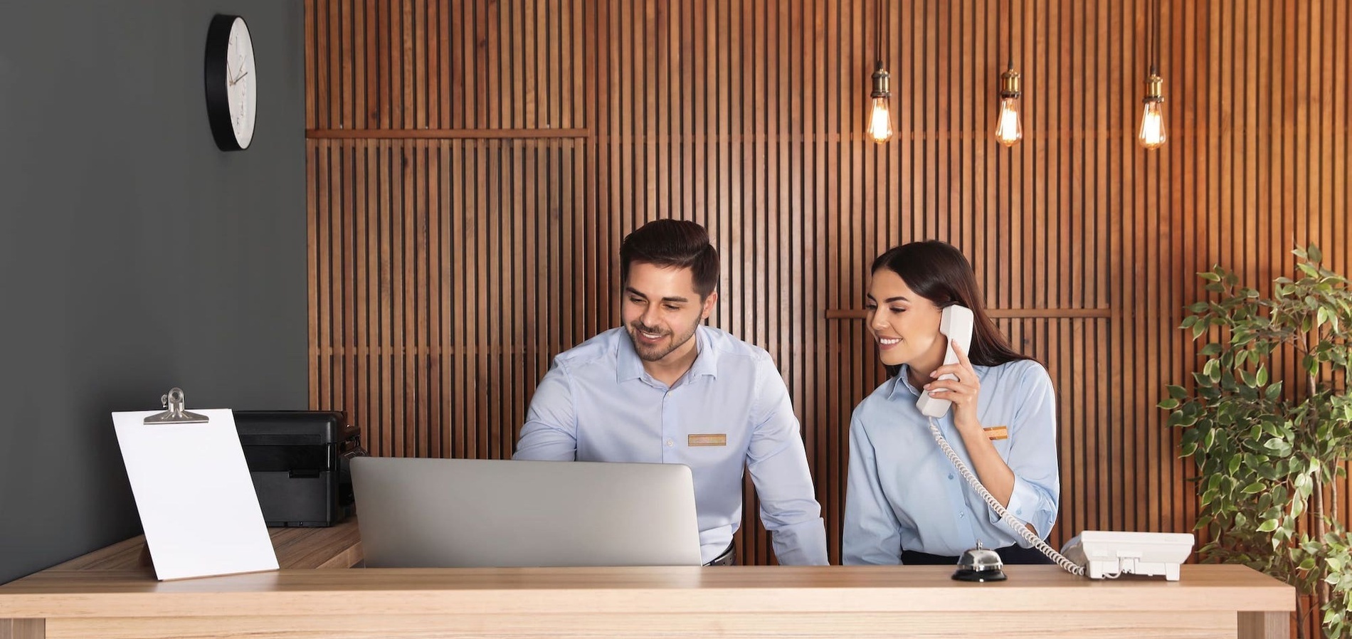 un hombre y una mujer están sentados en un mostrador frente a una computadora portátil
