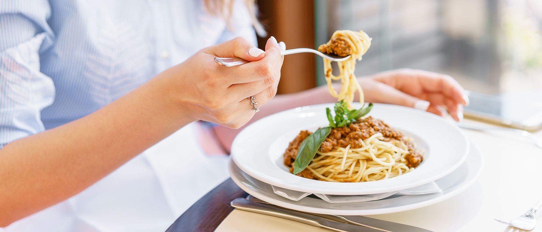 a woman is eating spaghetti with a fork