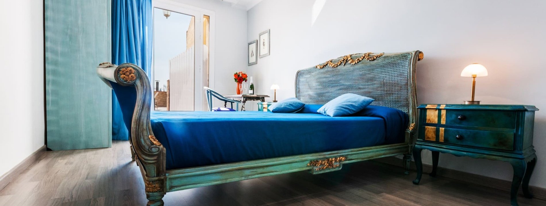 a bedroom with a blue bed and a blue nightstand