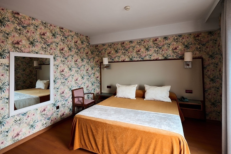 una habitación de hotel con una cama y un espejo