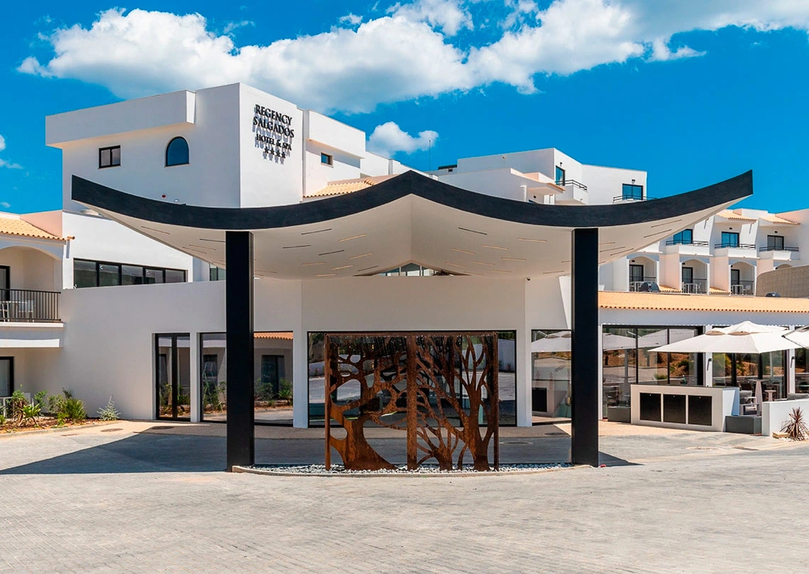 Regency Salgados Hotel & Spa: fachada moderna e pátio com escultura de árvore. Junte-se ao nosso Programa de Fidelidade!