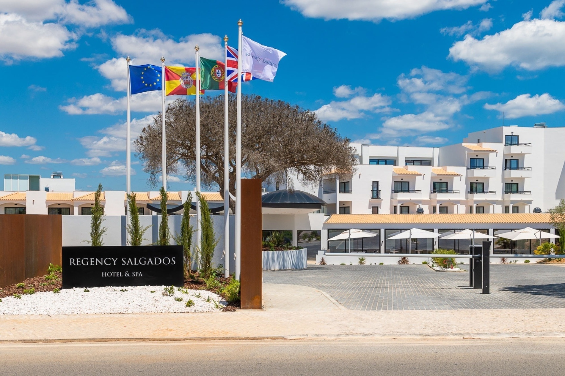 la entrada al hotel regency salgado está rodeada de banderas