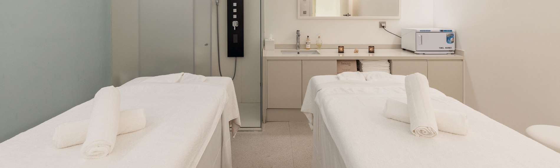 two massage tables in a room with a towel warmer