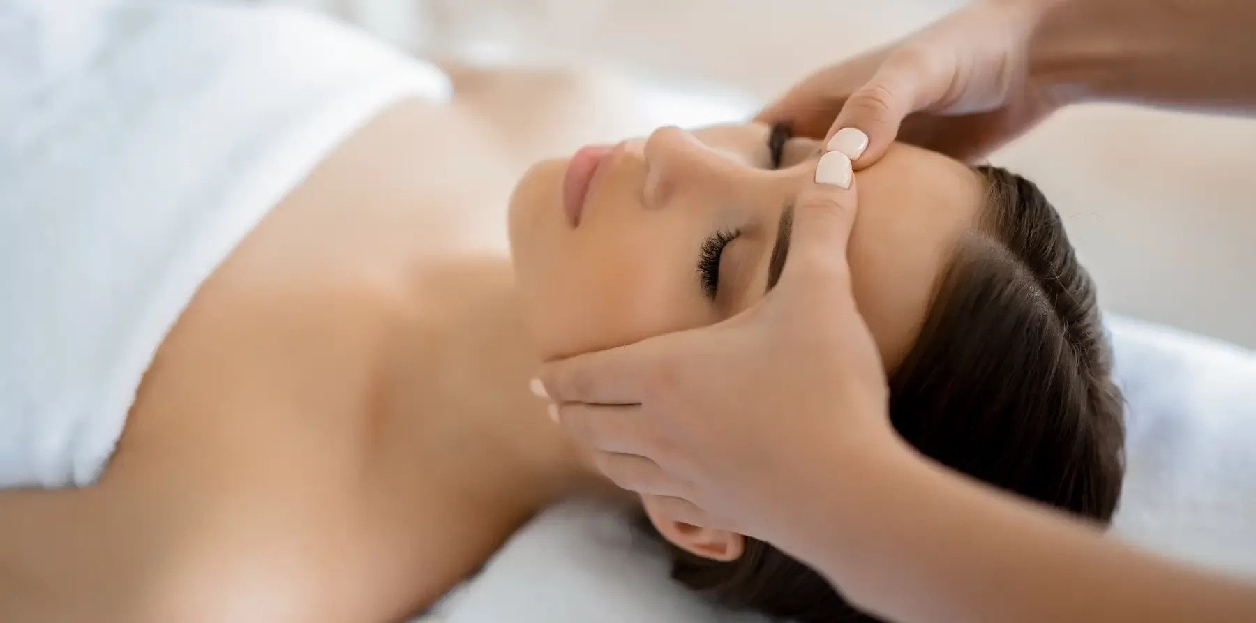 a woman is getting a head massage at a spa