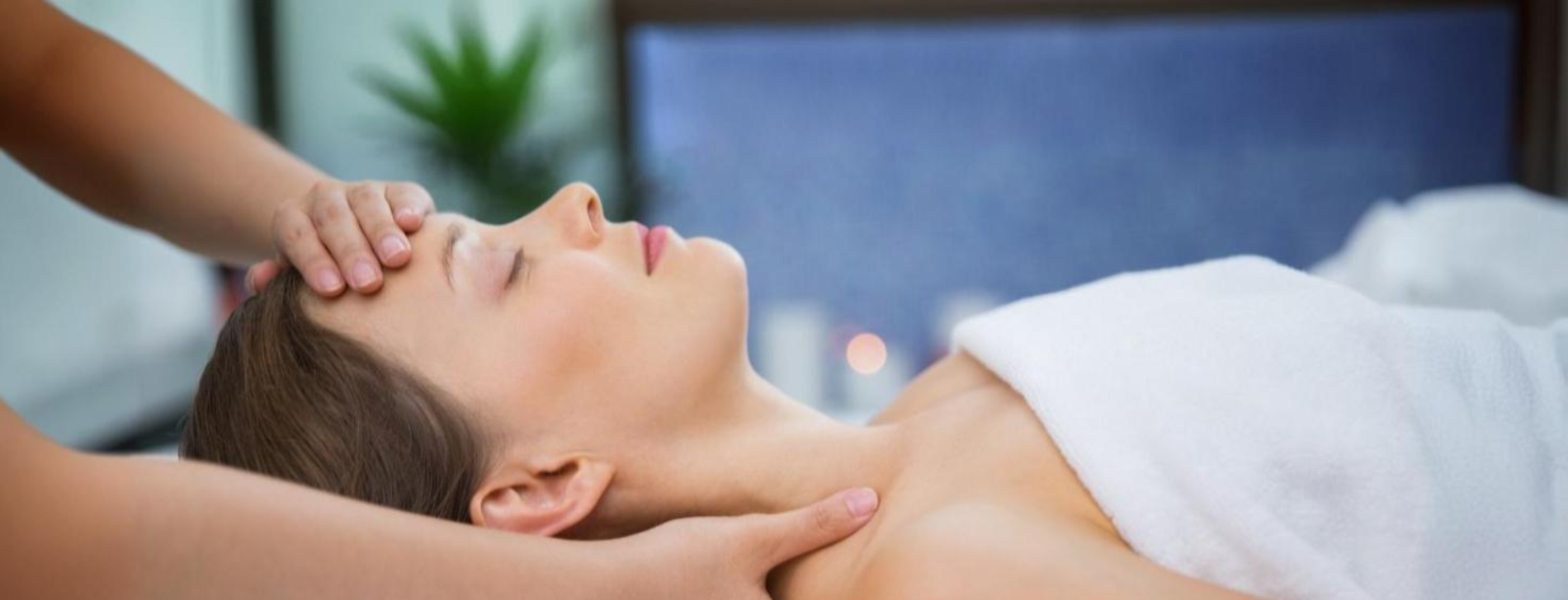 duas camas de massagem brancas com toalhas em cima