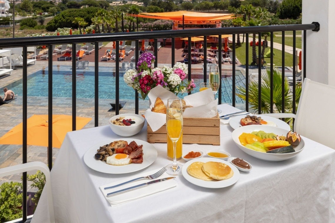 una mesa con platos de comida y bebidas en un balcón
