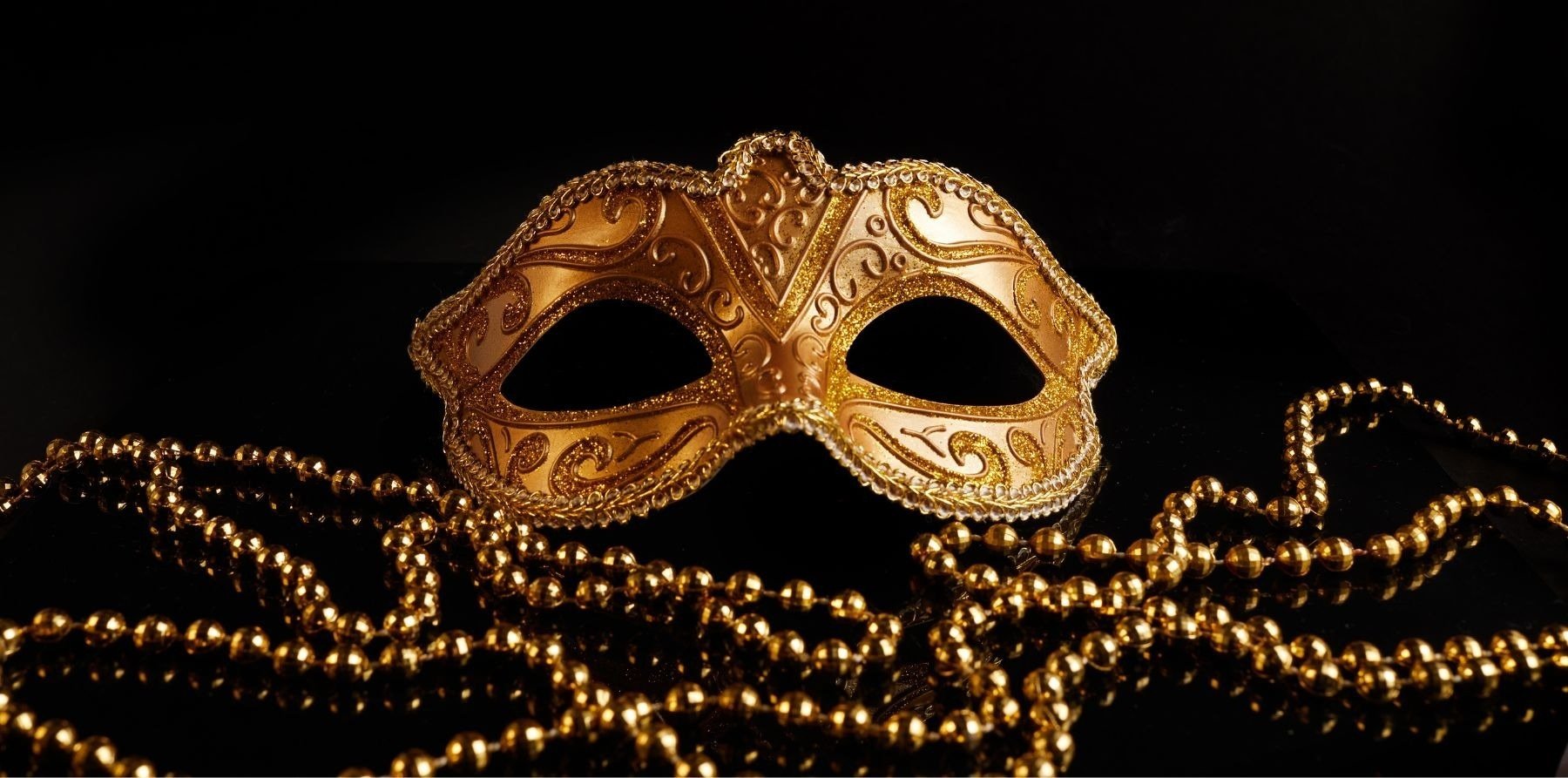 um fundo preto com máscaras douradas e a palavra masquerade ball reveillon