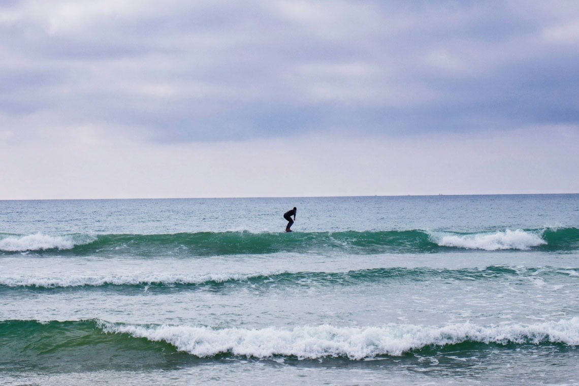 un surfista se sienta en una tabla de surf en el océano