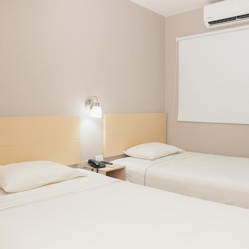 Habitación doble en Hotel Ribai Corporativa con camas individuales y aire acondicionado.