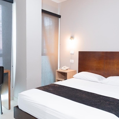 Habitación doble con cama cómoda y escritorio en Hotel Ribai Corporativa.