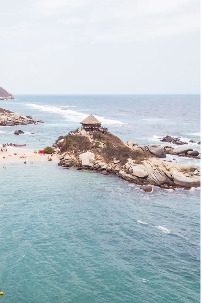 Hotel Ribai: Cabaña en islote rocoso con vista al mar turquesa.