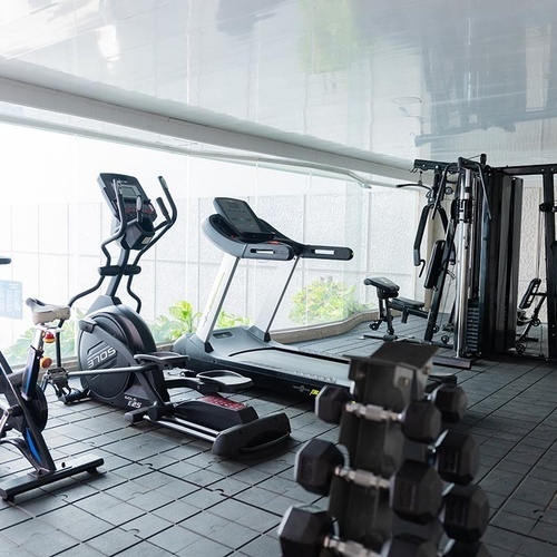 Gimnasio moderno Hotel Ribai Corporativa: elíptica, caminadora y pesas.