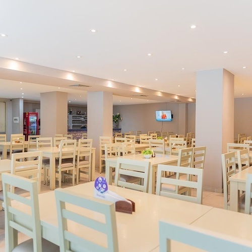 Comedor de Hotel Ribai Corporativa: mesas y sillas claras, ambiente luminoso.