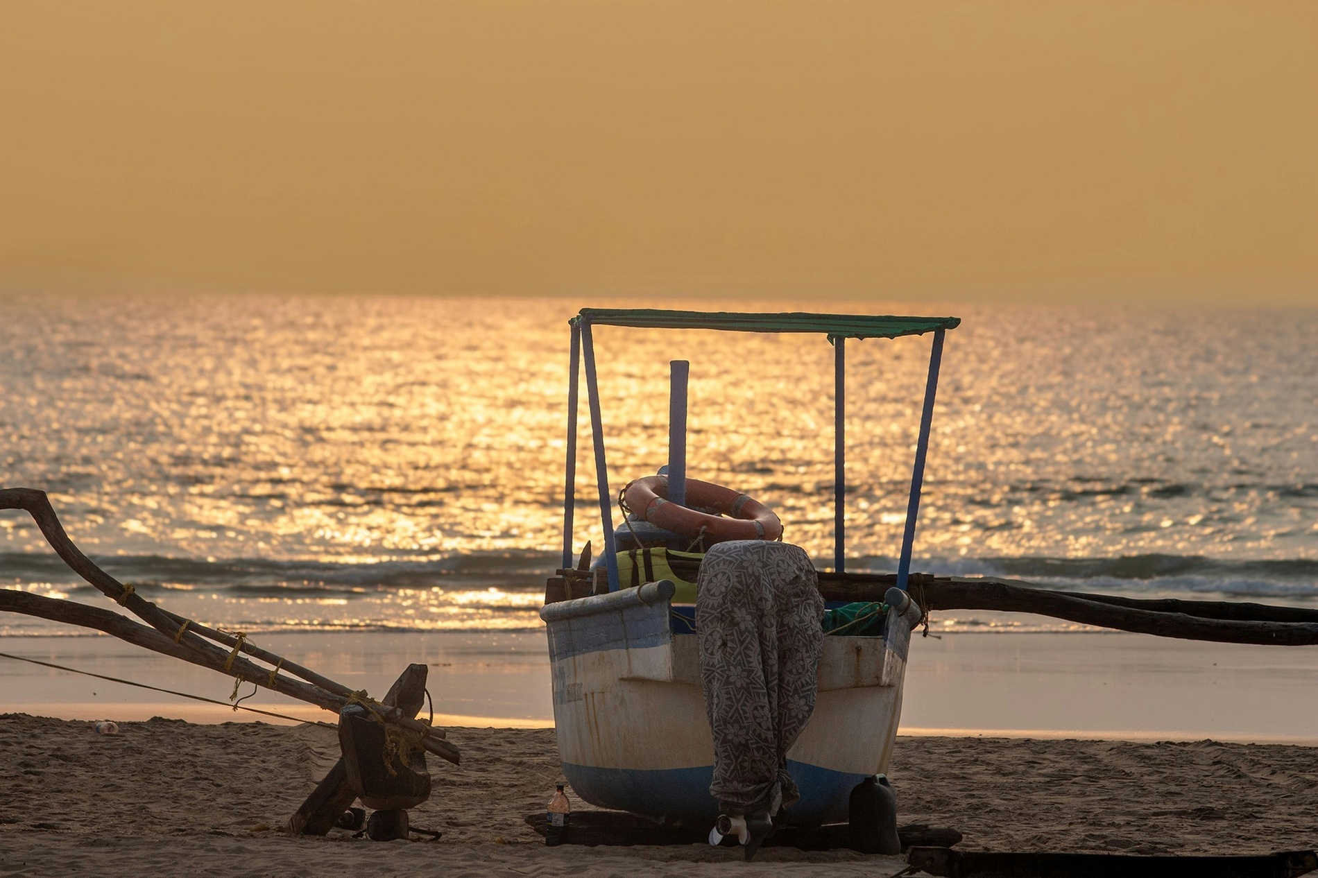 Barco en la playa al atardecer, perfecto para una estancia en Hotel Ribai Corporativa.