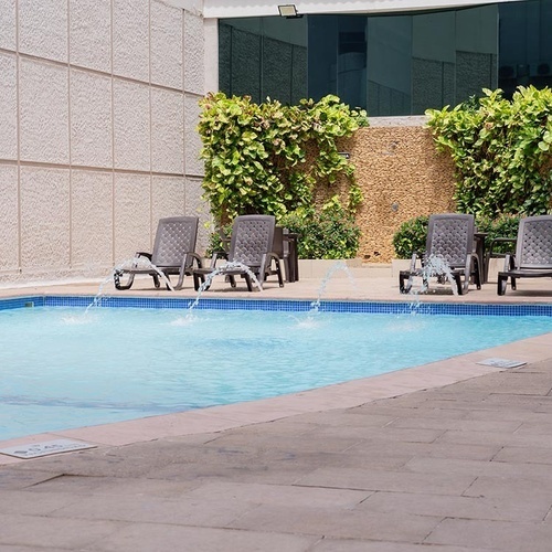 Piscina con tumbonas y fuentes en Hotel Ribai Corporativa.