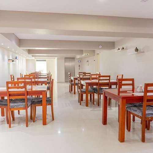 Comedor del Hotel Ribai Corporativa con mesas de madera y sillas grises.