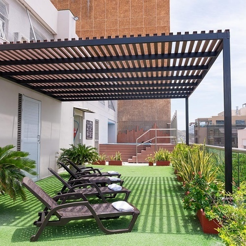 Terraza del Hotel Ribai Corporativa con tumbonas y vegetación.