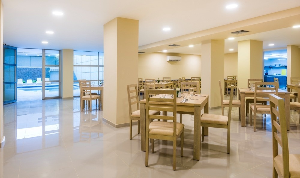 Restaurante interior moderno en Hotel Ribai Corporativa con mesas y sillas de madera.
