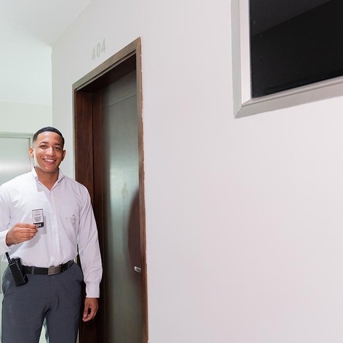 Guardia del Hotel Ribai Corporativa sonríe con credencial.