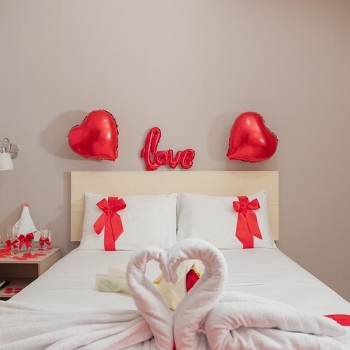 Habitación romántica Hotel Ribai Corporativa: cisnes de toalla, globos de corazón y detalle 
