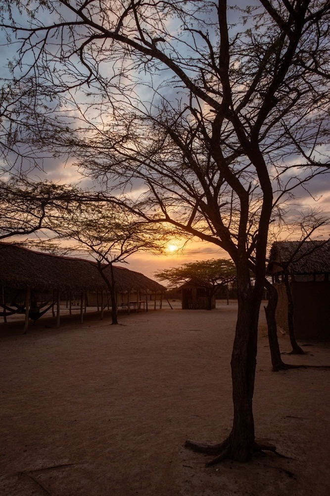 Atardecer en Hotel Ribai Corporativa con cabañas y árboles.
