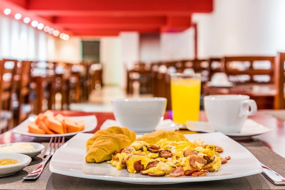 Desayuno continental en Hotel Ribai Corporativa: huevos, croissants y jugo.