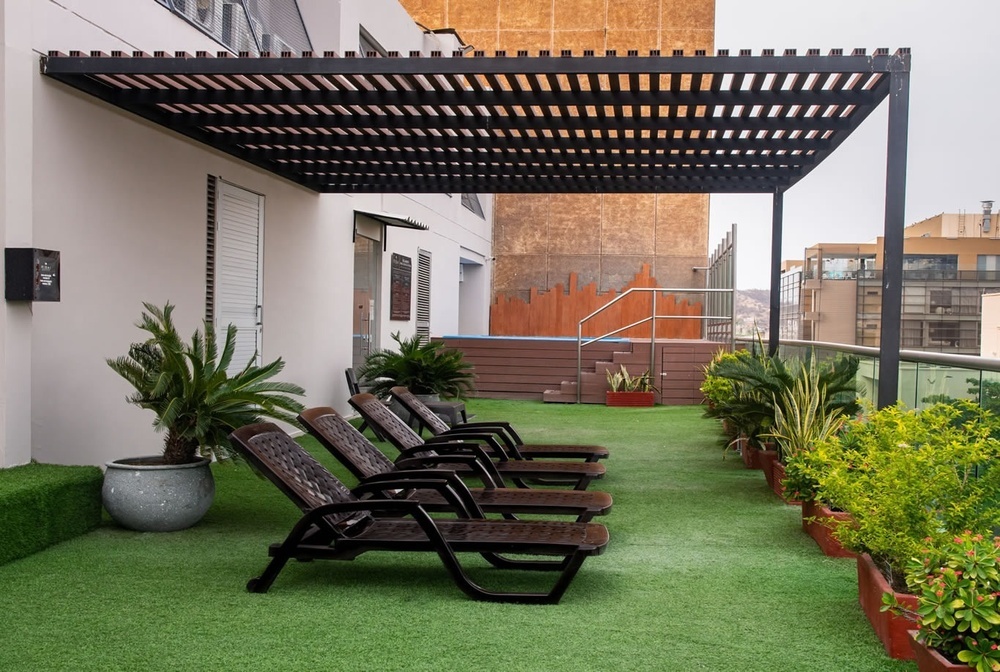 Terraza del Hotel Ribai Corporativa con tumbonas y piscina, ideal para relajarse.