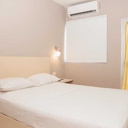 Habitación de hotel limpia y luminosa con cama cómoda en Hotel Ribai Corporativa.