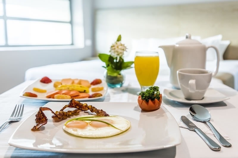 Desayuno continental en Hotel Ribai Corporativa: huevos, tocino, frutas y jugo.