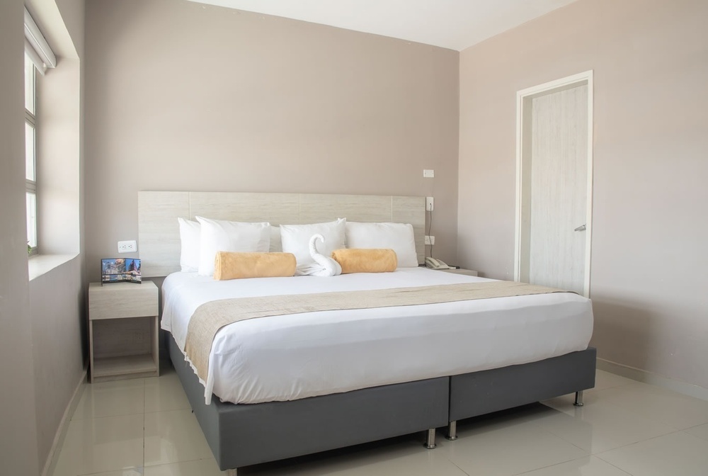 Habitación de lujo en Hotel Ribai Corporativa: cama king, toallas y decoración.
