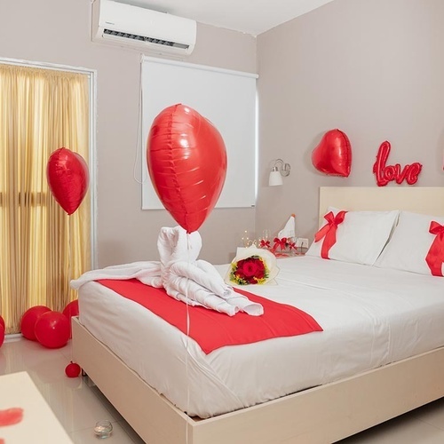 Habitación romántica decorada con globos y rosas en Hotel Ribai Corporativa.