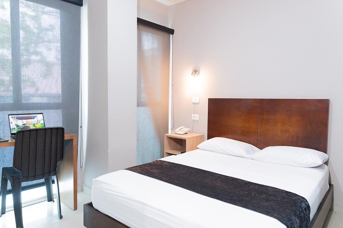 Habitación de hotel confortable con cama matrimonial y escritorio. ¡Reserva tu estancia en Ribai Hotels!